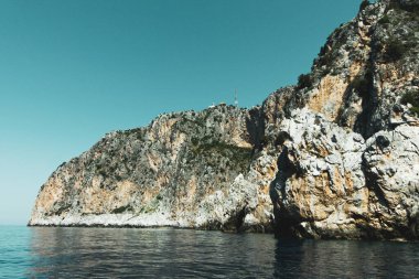İtalya 'nın Centola kentindeki Marinella' da açık bir gökyüzüne karşı mavi sudaki kayalık uçurumların güzel manzarası.