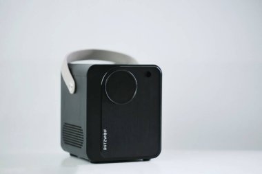 Uzaktan kumandalı Blitzwolf portatif projektörünün beyaz arka planda izole edilmiş bir fotoğrafı.