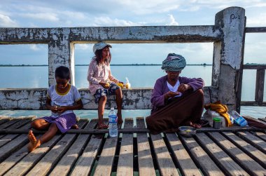 İskelede oturan çocukların fotoğrafı.