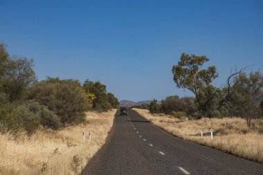Vahşi bir manzaranın yanında bir otoyolun perspektif görüntüsü.