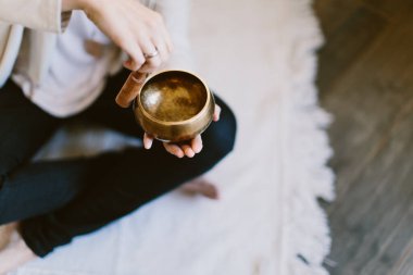 Tibet meditasyon kasesi kullanan bir kadının açı çekimi..
