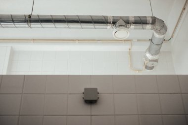 Banyo tezgahının üzerinde gümüş bir borunun düşük açılı çekimi.