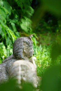 Kafasında kertenkele olan bir sfenksin dikey görüntüsü.