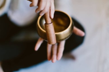 Tibet meditasyon kasesi kullanan bir kadının açı çekimi..