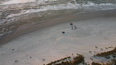Gün batımında kıyıda deniz dalgaları olan Ameland, Hollanda 'daki kumsalın kuş bakışı görüntüsü.