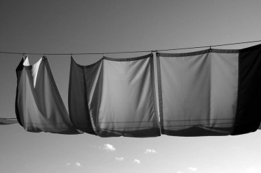 Pencere örtüsünün asılı olduğu gri ölçekli bir çekim