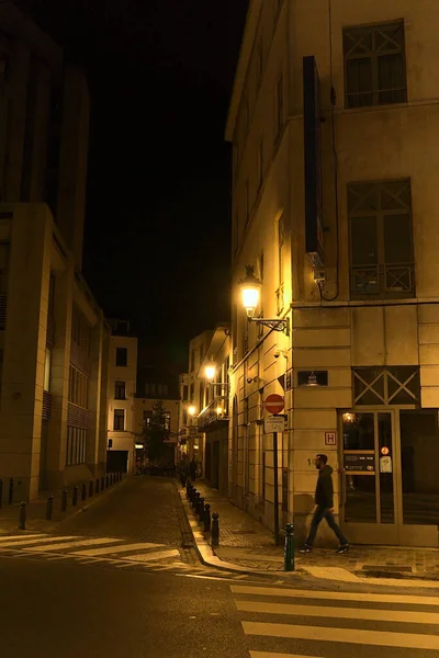 夜の街を歩く男の垂直ショット — ストック写真