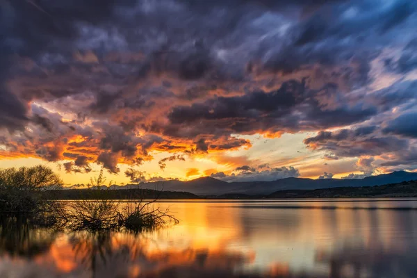 Ein Von Hügeln Umgebener See Unter Wolkenverhangenem Himmel Bei Sonnenuntergang — Stockfoto