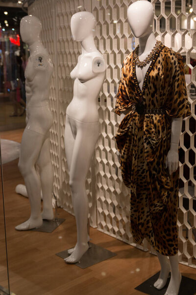 The naked and dressed mannequins standing at the entrance of the shop