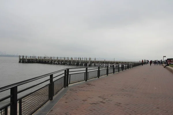在一个阴郁的日子里 人们在美国纽约市海景上的一个码头上散步的风景 — 图库照片