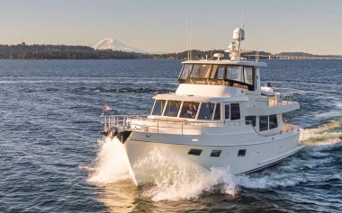 Su sıçramasıyla denizde yüzen beyaz bir yat.