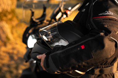 Gün batımında siyah motosiklet kaskı