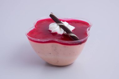 Beyaz arkaplanda pembe bir Panna Cotta 'nın yakın çekimi