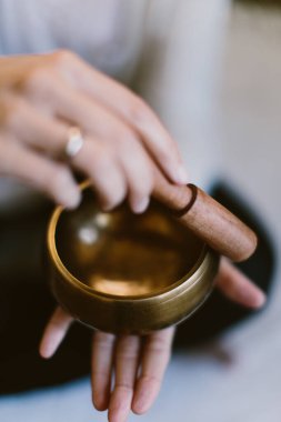 Tibet meditasyon kasesi kullanan bir kadının dikey görüntüsü..