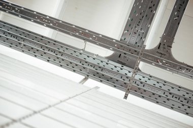 Beyaz bir odada gümüş yapısal elementlerin düşük açılı çekimi