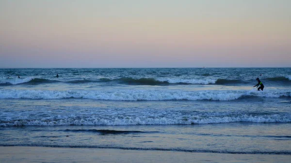 Μια Μακρινή Φωτογραφία Μιας Θάλασσας Μεγάλα Κύματα Και Ανθρώπους Κολυμπούν — Φωτογραφία Αρχείου