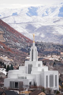 A vertical shot of LDS temple with golden Angel Moroni statue at the top in Drape, USA clipart