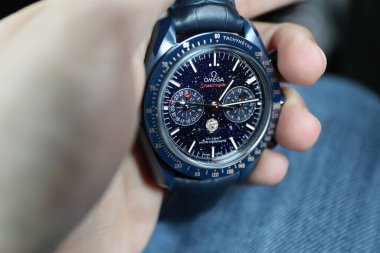 Omega Speedmaster 'ı tutan bir elin yakın çekimi.