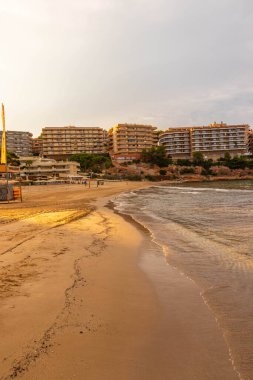 Salou 'da kumlu bir plajın dikey görüntüsü, arka planda apartmanlar, İspanya