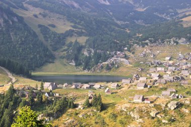 Bosna-Hersek 'in Vran Dağı yamacındaki Prokosko gölünün kıyısındaki köyün manzarası