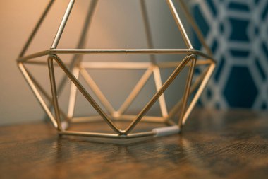 Ahşap bir yüzeyde, bir odada, bir lambanın yakın plan çekimi.