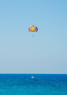 Denizin üzerinde Parasailing 'in keyfini çıkaran iki kişinin dikey görüntüsü..