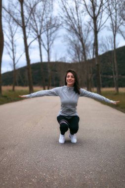 Soğuk bir günde parkta çalışan genç bir beyaz kadın.