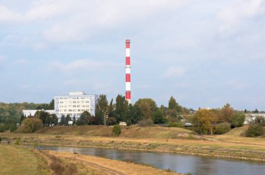 Poznan, Polonya 'daki Warta nehri kıyısındaki güzel bir baca ve şirket binası manzarası.