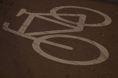 Asfalt yolda beyaz bir bisiklet tabelasının yakın çekimi.