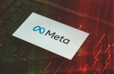 Laptop klavyesindeki cep telefonunun ekranındaki Meta logosunun yakın çekimi