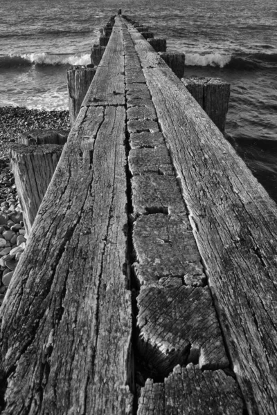Svislý Snímek Dřevěného Mola Vlnitém Moři Stupních Šedi — Stock fotografie