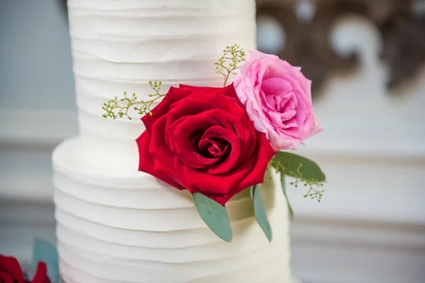 一张有玫瑰的白色婚礼蛋糕的特写照片 — 图库照片