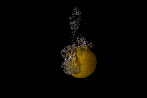 黒い背景に水が飛び散ったレモンのクローズアップ — ストック写真