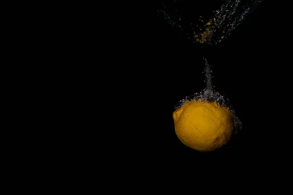 Suda Boğulan Bir Limonu Siyah Bir Arka Planı Olan Bir — Stok fotoğraf