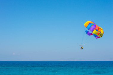 Yunanistan 'ın Akti Kanari Sahili' nde Parasailing 'in keyfini çıkaran iki kişinin güzel manzarası