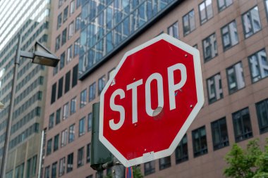 Bir dur işaretinin yakın çekimi ve arka planda modern bir bina.