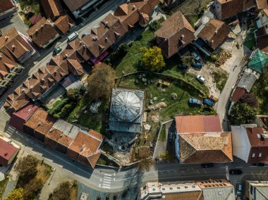 Evi ve park halindeki arabaları olan bir şehir manzarası.