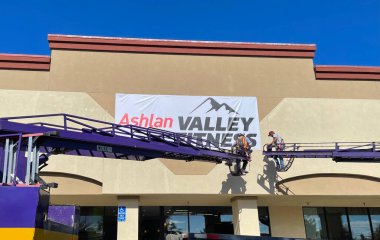 Endüstriyel vinçlerde çalışan işçiler Ashlan vadisinin önünde çalışıyor.