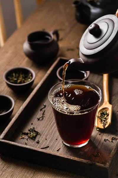 Pionowe Ujęcie Nalewania Czarnej Herbaty Czajnikiem — Zdjęcie stockowe