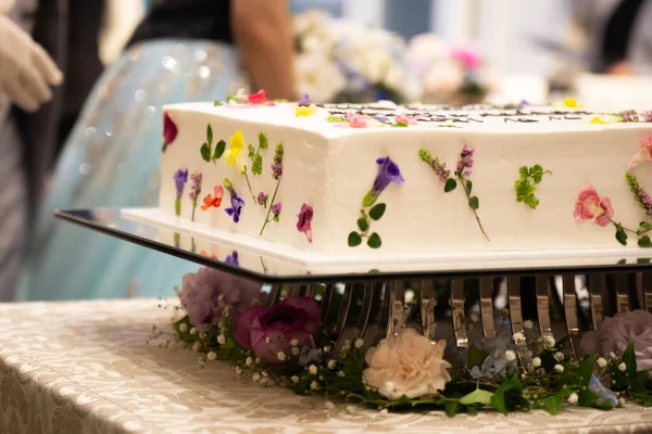 一张白色蛋糕的特写照片 桌上放着鲜花 — 图库照片