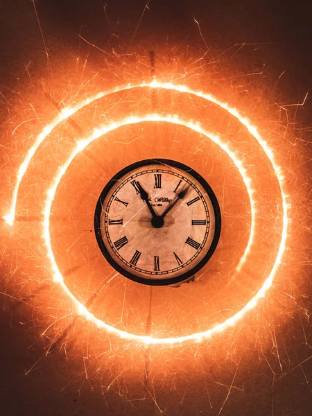 時計の周りに火花の渦の垂直ショット — ストック写真
