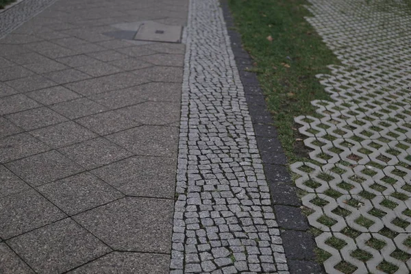 Piękne Ujęcie Szczegółowej Faktury Zbliżeniowej Brukowej Ulicy Różnymi Płytkami Trawą — Zdjęcie stockowe