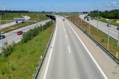 Farklı arabalar ve yol işaretleri olan güzel bir otoyol görüntüsü.