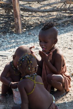 Dışarıda, Namibya 'da oynayan Himba kabilesinden sevimli çocukların dikey çekimi.