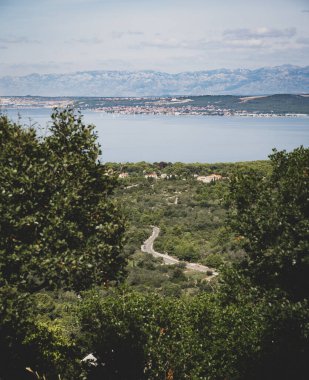 Hırvatistan 'da dağlar ve ağaçlarla çevrili bir deniz manzarası