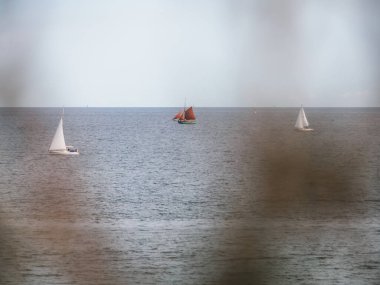 Okyanusta yüzen teknelerin manzarası açık gökyüzü arka planında