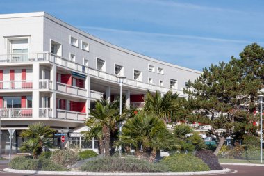 Güneşli bir günde yol kenarında beyaz bir bina.