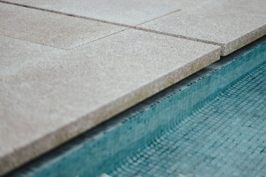 Taşların yanında mavi bir mozaik havuz.