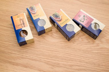 Tahta bir arka planda, metin alanı olan karton paketlerdeki doğal organik bitkiler ve baharatlar.