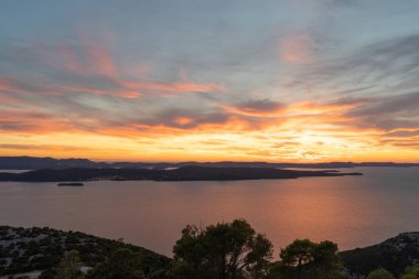 Hırvatistan 'da gün batımında dağlarla çevrili güzel bir denizin hava manzarası
